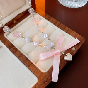 Detail of beaded necklace featuring pink stars and polished silver heart pendant in a gift box