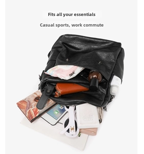 Spacious interior of black pebble leather backpack showing organized storage for essentials