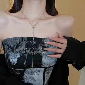 Silver Y-shaped lariat necklace with minimalist twist knot design on a fashion model
