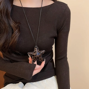 Close-up of leopard print star pendant necklace worn by a model in a vintage style