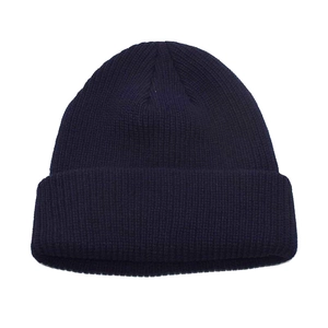 Close-up of thick navy blue knit texture and wide folded cuff on this winter beanie hat