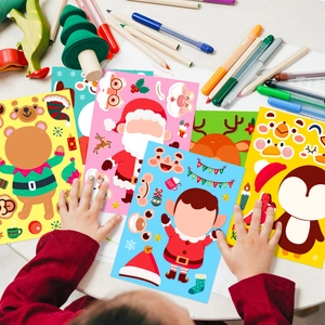 Kids hands playing with DIY Christmas character stickers on a white desk setup