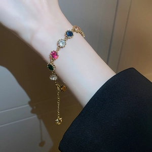 Detail of colorful gemstone gold bracelet with adjustable chain on wrist