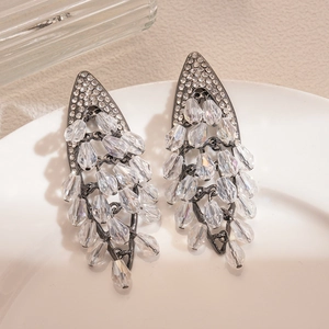 Nahaufnahme der hohlförmigen Rauten-Ohrringe mit Diamantbesatz und Kristallen
