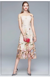 Close-up of exquisite multi-color floral embroidery on beige mesh waist-slimming dress