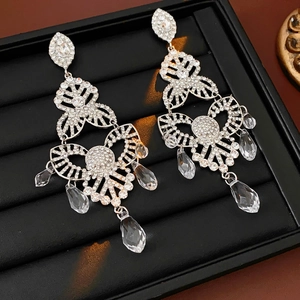 Macro detail of silver floral fringe earrings with waterdrop crystals in a black gift box