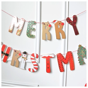 Detail of Merry Christmas letter banner with red and white rope on a white wall