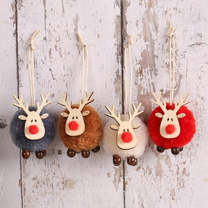 Set of four plush reindeer Christmas tree hanging ornaments with wood antlers on wooden background
