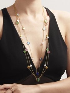 Detail einer mehrlagigen Gold-Pulloverkette mit Cat-Eye-Steinen und Perlen-Akzenten