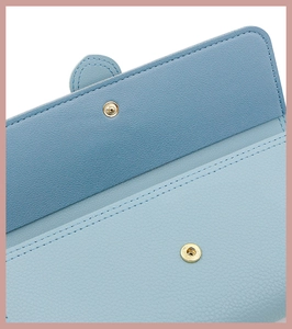 Close-up of light blue lychee pattern leather wallet with snap button and fine stitching
