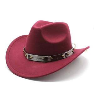 Detail of dark red wool felt cowboy hat with metallic rivets and decorative band