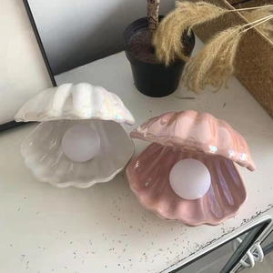 Top view of pearl white and pink shell night lights with glowing LED pearl inside