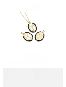 Detail of 18K gold-plated copper cross pendant with red crystal inlay and black trim