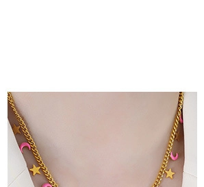 Close-up of gold chain necklace featuring star charms and pink crescent moon pendants
