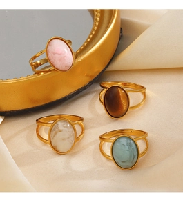 Set of four gold adjustable rings featuring colorful oval resin stones on silk fabric