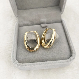 Detailed shot of gold-plated thick oval hoop earrings inside a velvet jewelry box