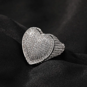 Macro shot of a silver heart-shaped ring with pavé 3A cubic zirconia on dark silk fabric