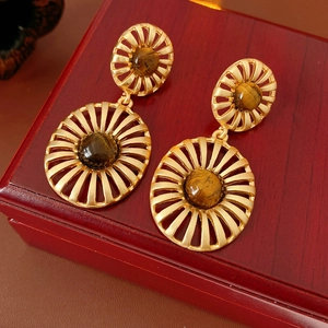 Detail of vintage gold-toned earrings featuring tiger eye stone and sunburst pattern
