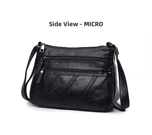 Detail view of black washed PU leather crossbody bag with multiple zippers and soft texture