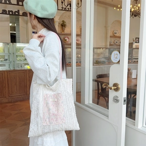 Lace tote bag with vintage floral pocket and pink straps shown on female model
