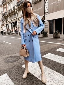 Detail of double-breasted sky blue wool coat with notch lapels and black buttons