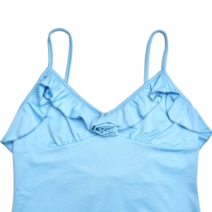 Detail view of light blue V-neck top with ruffled edges and fabric flower embellishment