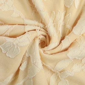 Macro di tessuto jacquard giallo chiaro con dettagli di trama a spirale e ricamo
