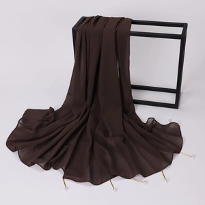Close-up of dark brown chiffon shawl featuring golden metal tubes and pearl edge decorations