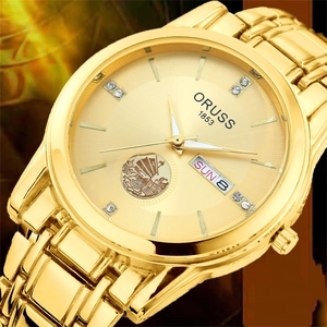 Macro view of gold quartz watch dial with sailboat relief and double calendar display