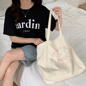 Detail of a large off-white canvas tote bag with pink PARIS embroidery for daily use
