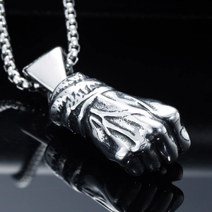 Macro shot of silver clenched fist pendant in stainless steel with metal chain necklace
