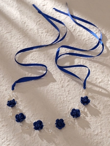 Detail of blue fabric roses and white pearls hand-woven with silver wire on a bridal headband