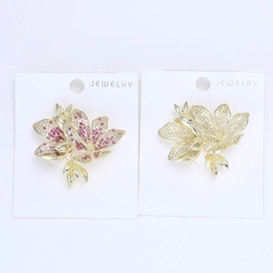 Close-up of elegant flower brooches with pink and clear cubic zirconia in gold setting