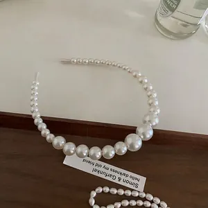 Detail of gradient pearl headband with elegant luster on a vintage wooden tray