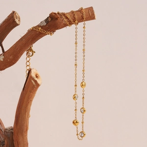 Détail du collier à billes plaqué or 18 carats avec cinq pendentifs ronds en zircon