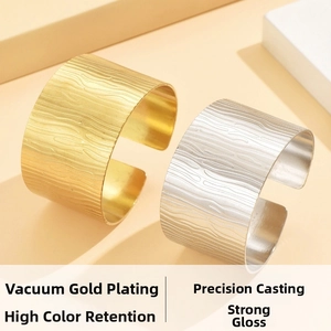 Macro detail of gold and silver C-shaped stainless steel bangles with irregular textures