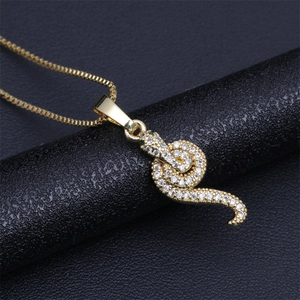 Macro detail of gold-plated snake pendant with sparkling zircon on a sleek box chain