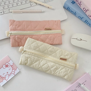 Close-up of quilted candy color pencil bags with diamond patterns and zip closure