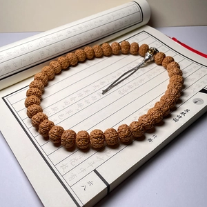 Macro detail of natural Rudraksha seed beads with metallic accents on vintage calligraphy