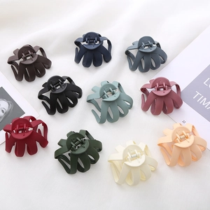 Set of 10 matte 8cm octopus hair claws in various muted colors on white fabric