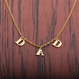 Collier en acier inoxydable doré avec pendentif DAD sur fond de bois sombre