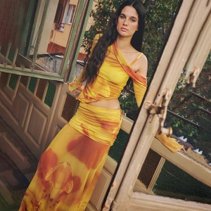 Dettaglio del set due pezzi tie-dye giallo e arancione con top a spalle scoperte e gonna lunga