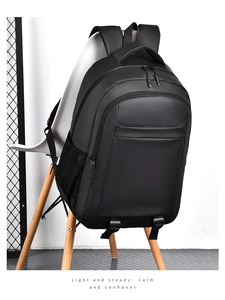 Close-up of black travel backpack with side mesh pocket and smooth waterproof fabric