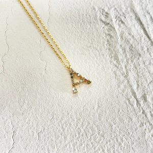 Detailed shot of 18k gold letter A pendant with colorful gemstones and rhinestones