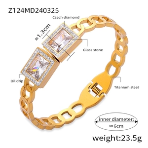 Detailed macro view of gold titanium bangle featuring hollow geometric crystal settings