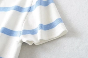 Detail of light blue and white striped knit cuff showing fine stitching and texture