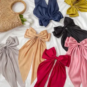 Satin bow hair clip with long ribbons in multiple colors on elegant white background