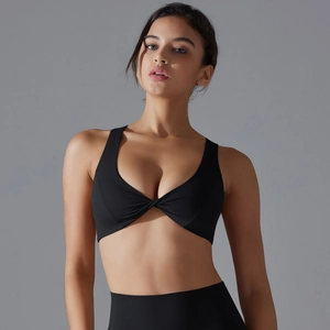 Detailed close-up of the front twist knot design on this black sports bra