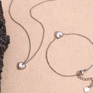 Détail d'un ensemble de bijoux coeur avec incrustation de nacre et perles en argent