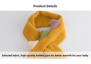 Detail view of yellow knitted baby scarf with colorful 3D dinosaur spine decorations